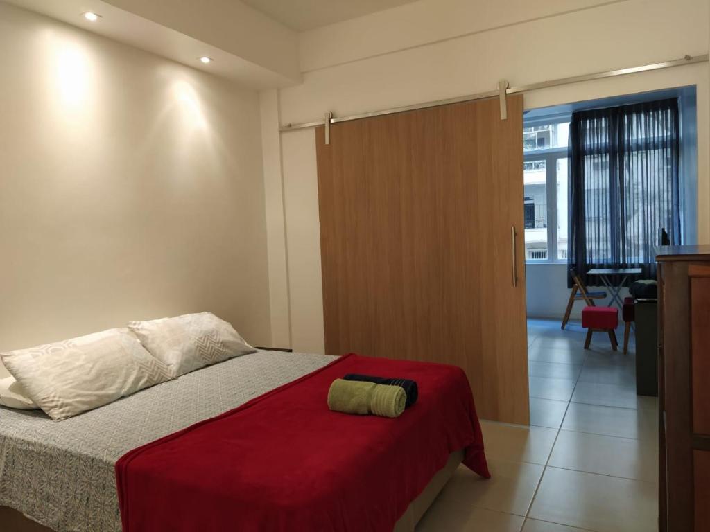 Apartamento Copacabana: aconchego, conforto, privacidade في ريو دي جانيرو: غرفة نوم بسرير وبطانية حمراء