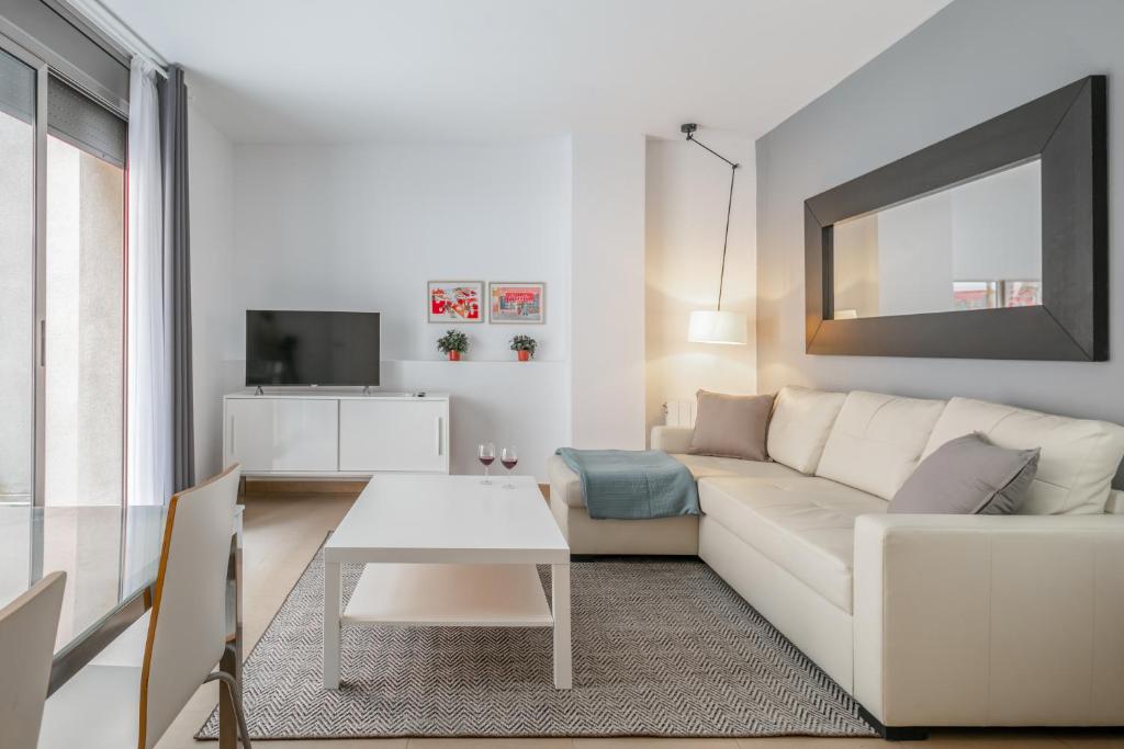 a white living room with a white couch and a table at Inside Barcelona Apartments Salva in Barcelona