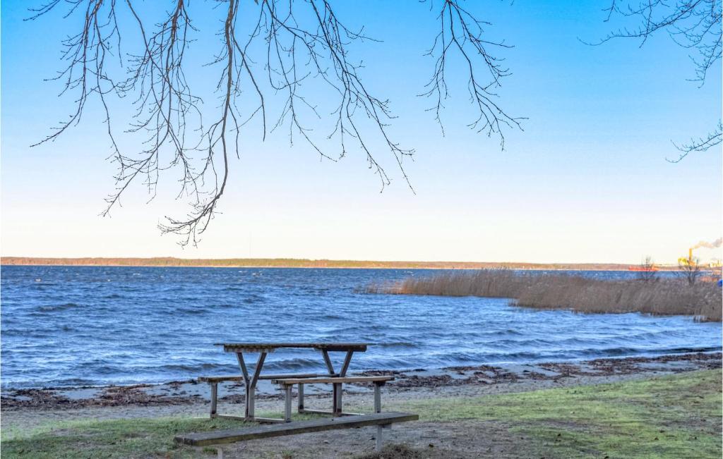 a picnic table next to a body of water at Stunning Apartment In Sölvesborg in Sölvesborg