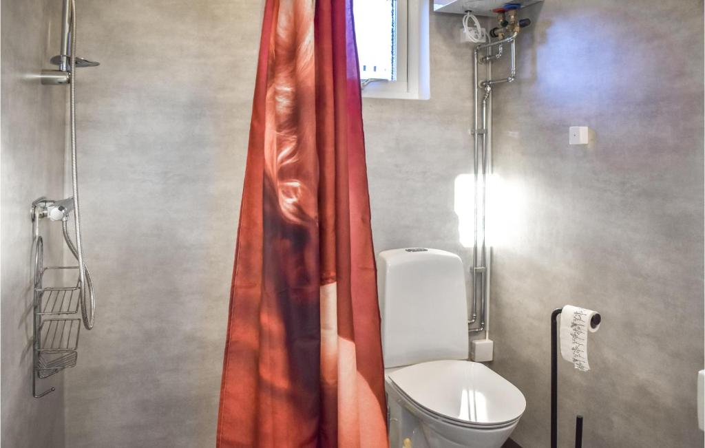 a bathroom with a toilet and a red shower curtain at Stunning Apartment In Sölvesborg in Sölvesborg