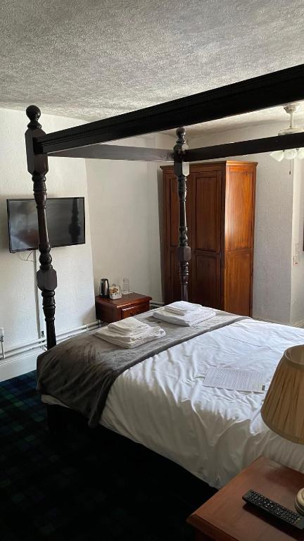 a bedroom with a large bed with a wooden frame at Old Court Hotel & Apartments in Symonds Yat