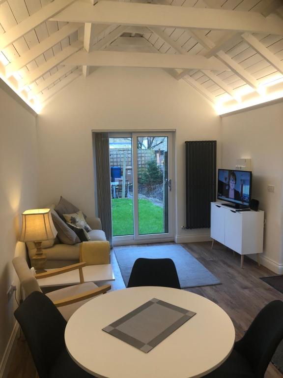 a living room with a table and a couch at Unique one bed contemporary bungalow town centre in March