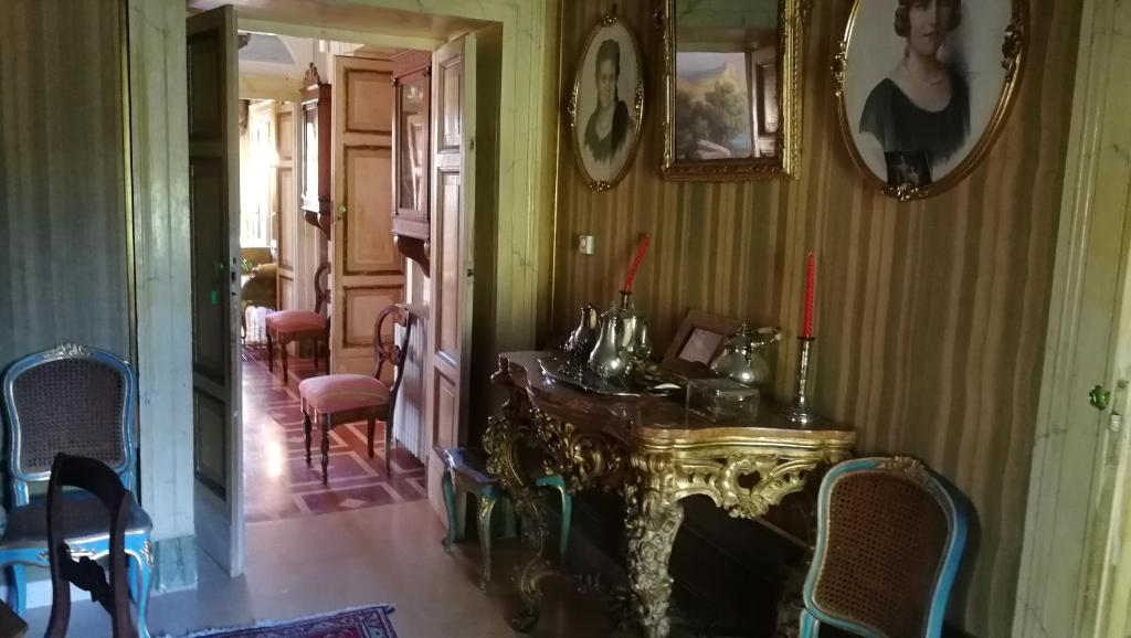 pasillo con mesa y sillas en una habitación en camere in Villa d'epoca en Abbazia di Santa Maria in Selva