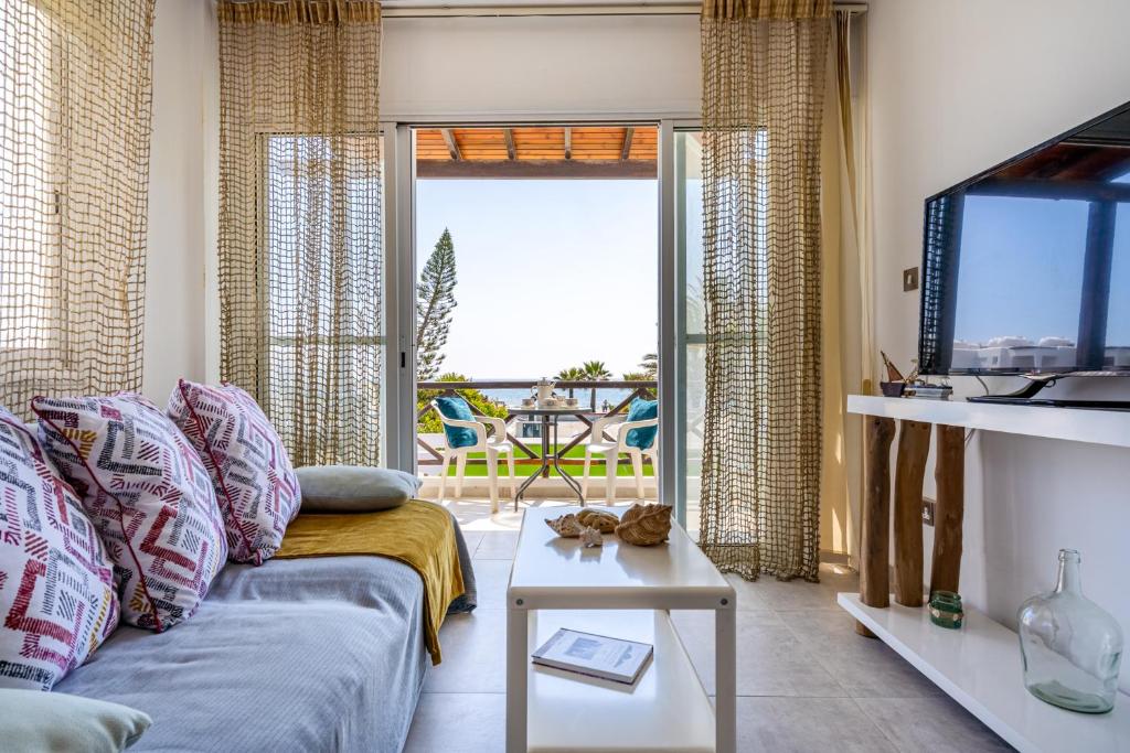a living room with a couch and a view of the ocean at 1- Bedroom Apartment near Meneou Beach in Larnaka