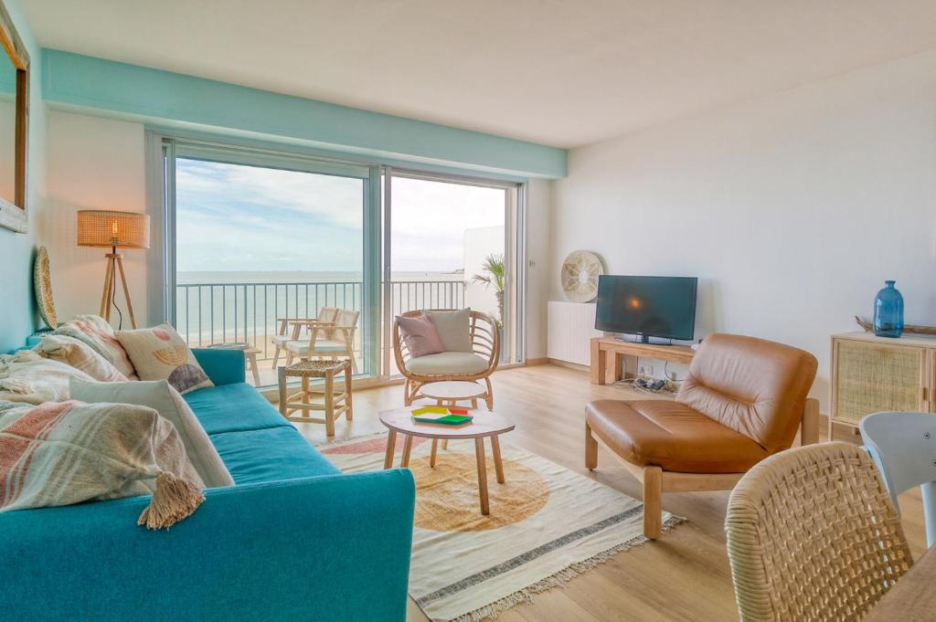 sala de estar con sofá azul y TV en Vue sur mer La Baule Hydra en La Baule