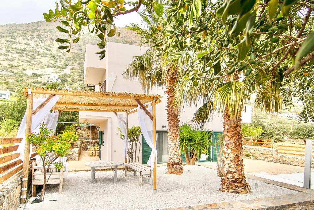 a house with palm trees in front of it at Haroupia The Residence in Kalidhón