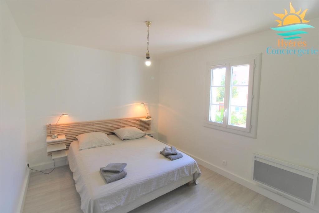 um quarto branco com uma cama e uma janela em Duplex au coeur du Port d'Hyères- Plages Parking BY HC em Hyères