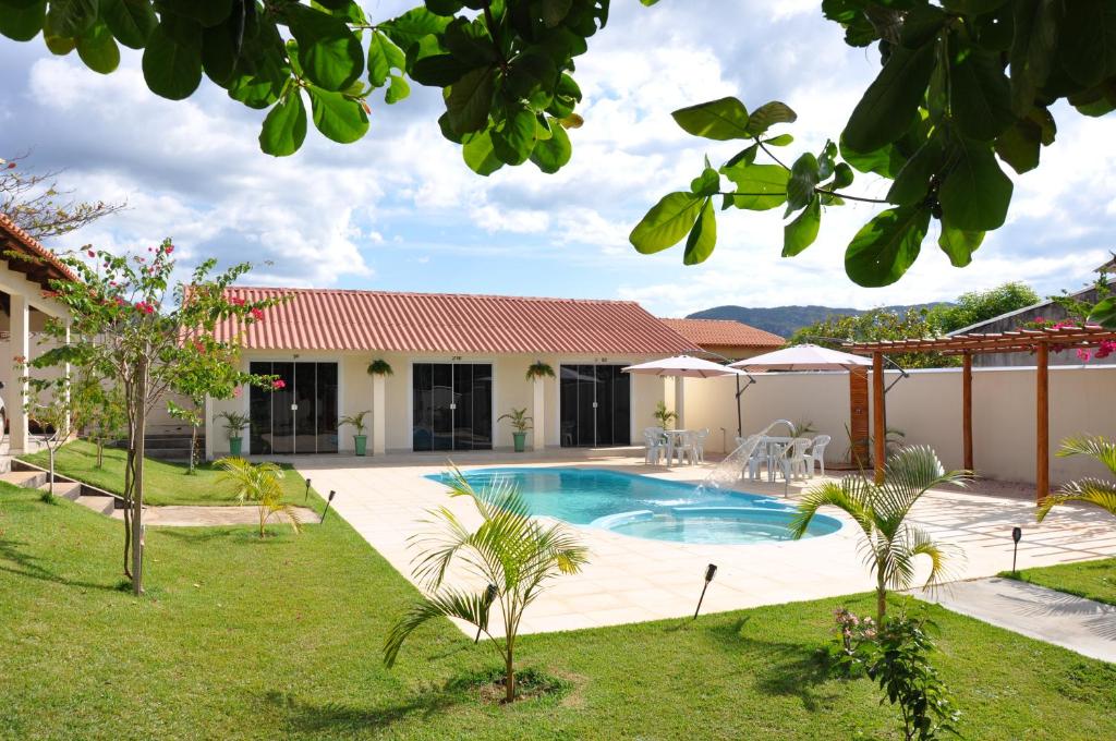 a house with a swimming pool in a yard at Suites Bougainville in Cavalcante