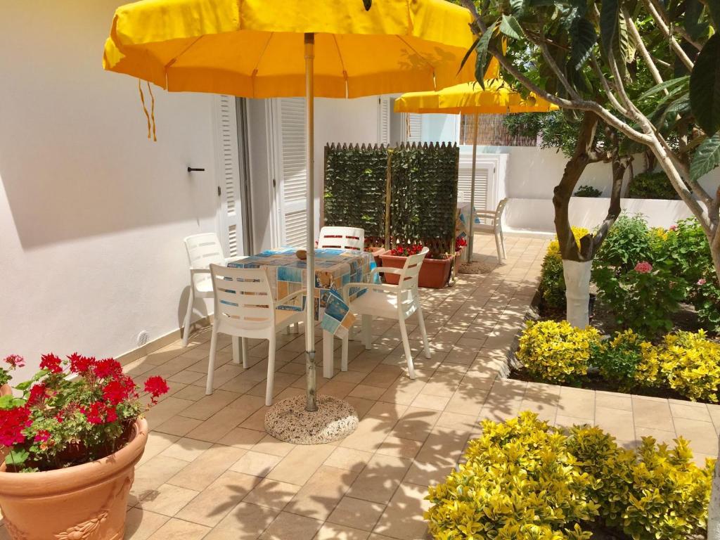 einen Tisch und Stühle unter einem Sonnenschirm auf einer Terrasse in der Unterkunft Vento di Terra Ponza in Ponza