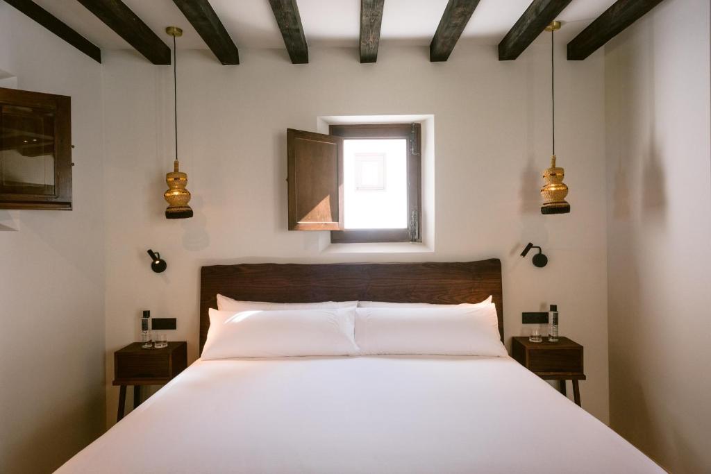 a bedroom with a white bed and white walls at Casa Maca in Ibiza Town