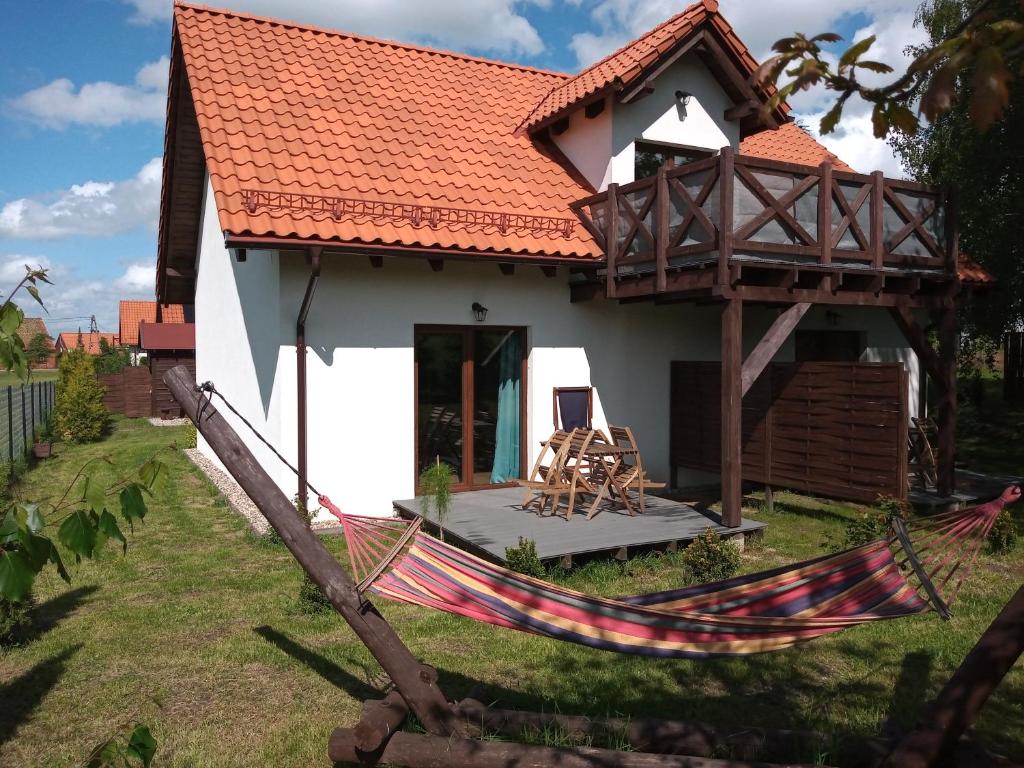 Biały dom z hamakiem przed nim w obiekcie Mazurska Apartamenty w Rydzewie