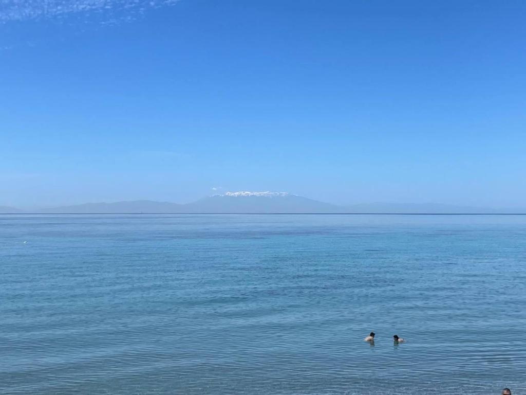 two people swimming in a large body of water at “Sound of the sea” first line studio in Skála Foúrkas