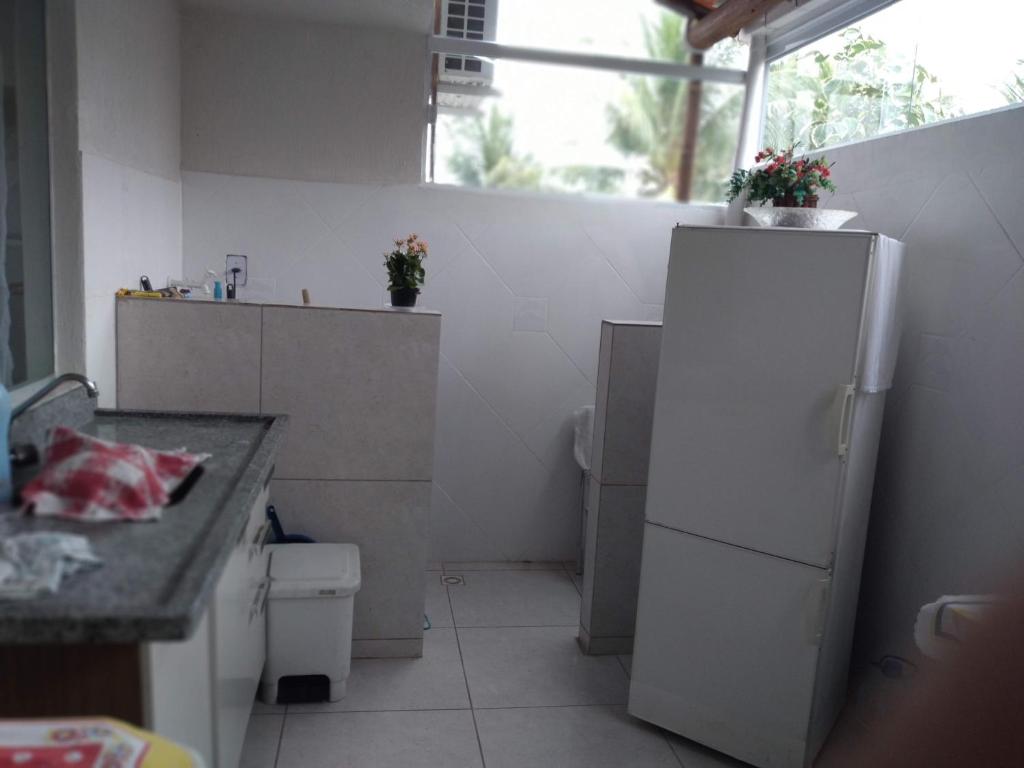 a small kitchen with a refrigerator and a sink at condominio moradas de guarajuba in Guarajuba