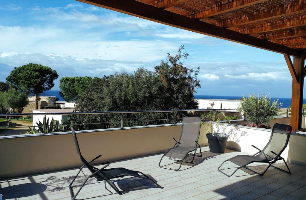 two chairs on a balcony with a view of the ocean at Casa Balanina in Lumio