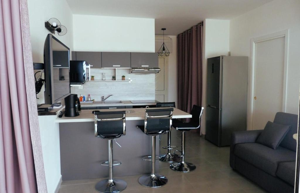 a kitchen with a counter and bar stools and a couch at Casa Balanina in Lumio