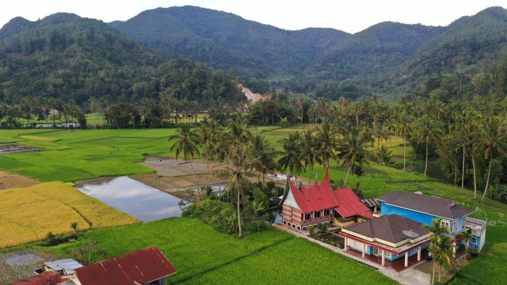 an aerial view of a house with mountains in the background at Rumah Gadang Simarasok in Baso