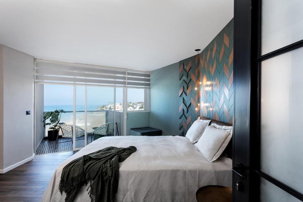 a bedroom with a bed and a view of the ocean at Seaview Stylish Apartment with Balcony in Herzliya