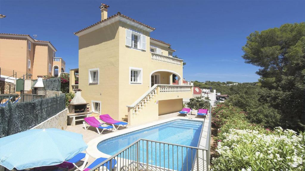 a villa with a swimming pool in front of a house at Villa Miel by Sonne Villas in Cala Galdana
