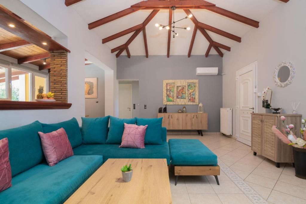 un soggiorno con divano blu e tavolo di Stranis Hill House Zakinthos ad Akrotiri