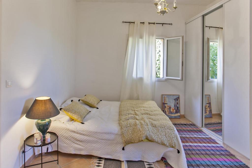Santa-Reparata-di-BalagnaにあるCasa Gentileの白いベッドルーム(ベッド1台、ランプ付)