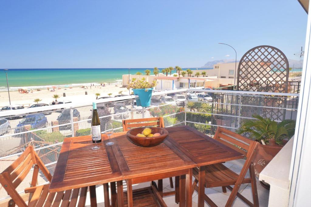 einen Tisch mit einer Obstschale auf einem Balkon mit Strandblick in der Unterkunft Villa Mirage in Alcamo