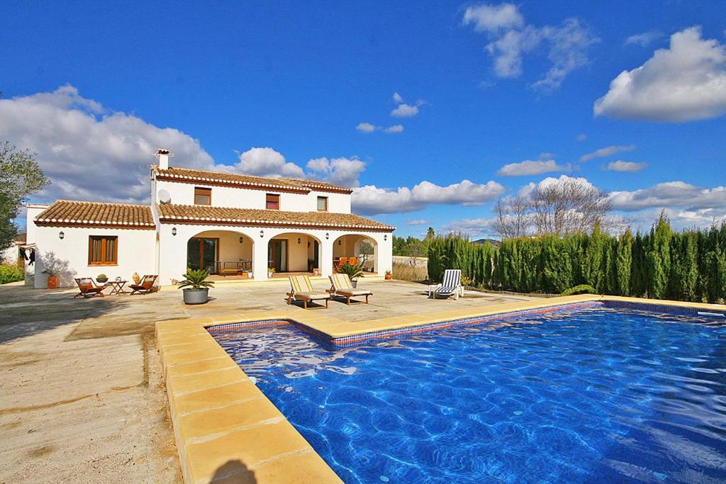 une villa avec une piscine en face d'une maison dans l'établissement Villa Tranquila - PlusHolidays, à Benissa