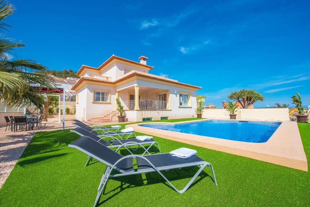 a villa with a swimming pool and lawn at Villa Maximo - PlusHolidays in Calpe