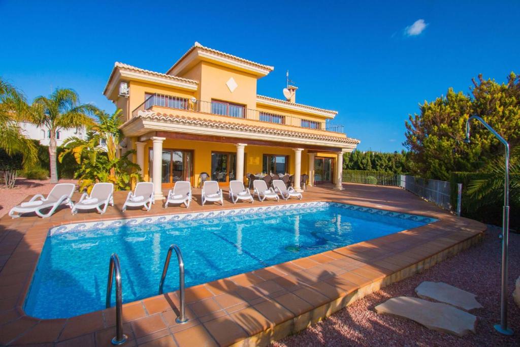 a villa with a swimming pool in front of a house at Villa Bellavista - Plusholidays in Calpe