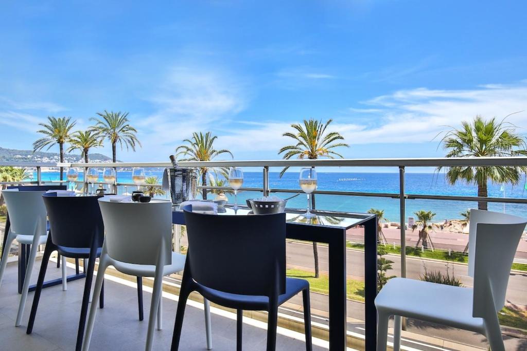 une table et des chaises sur un balcon avec vue sur l'océan dans l'établissement Sublime Appartement Promenade des Anglais (3), à Nice