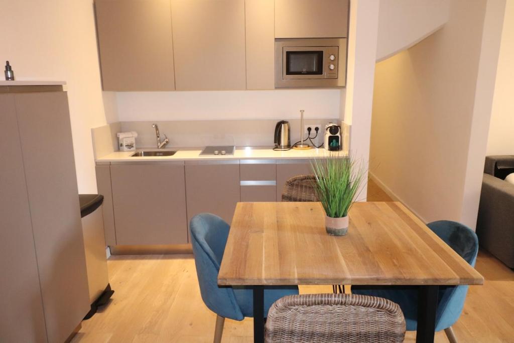 une cuisine et une salle à manger avec une table et des chaises en bois dans l'établissement Superbe Appartement au coeur de la vieille ville, à Villefranche-sur-Mer
