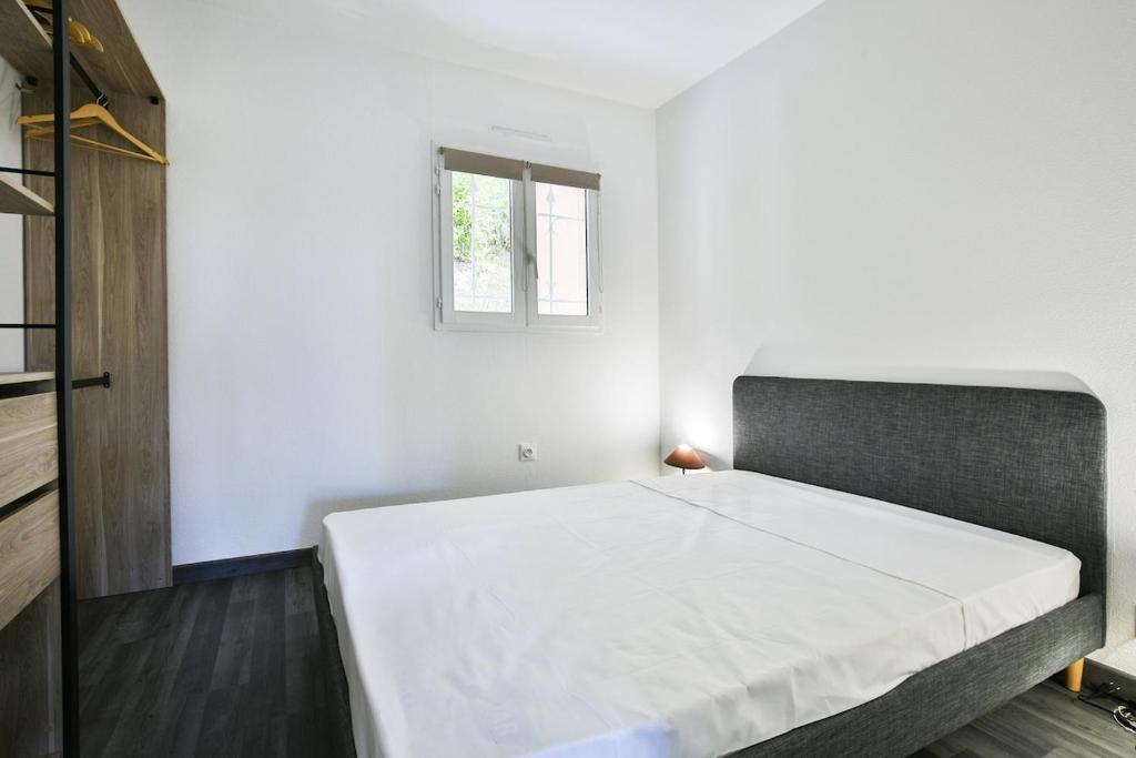 - une chambre avec un lit dans une pièce dotée d'une fenêtre dans l'établissement Superbe 2 pièce tout confort , PISCINE /AC/PARKING, à Villefranche-sur-Mer