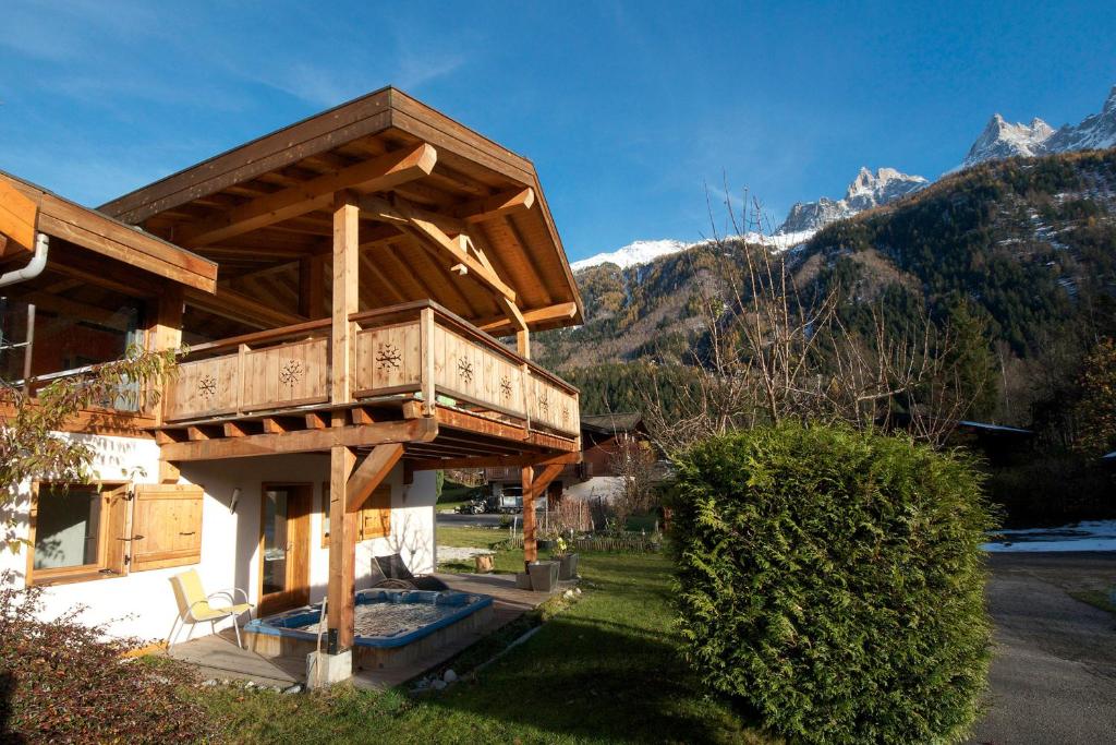 un bâtiment avec un balcon donnant sur les montagnes en arrière-plan dans l'établissement Chalet Minouche, à Chamonix-Mont-Blanc