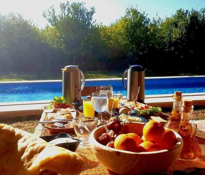 a table with a bowl of fruit on top of it at Dar Khedija in El Kheriba