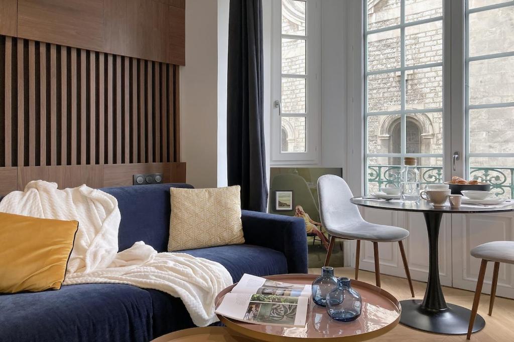 Superbe studio Plage/ Promenade des Anglais 102 في نيس: غرفة معيشة مع أريكة زرقاء وطاولة