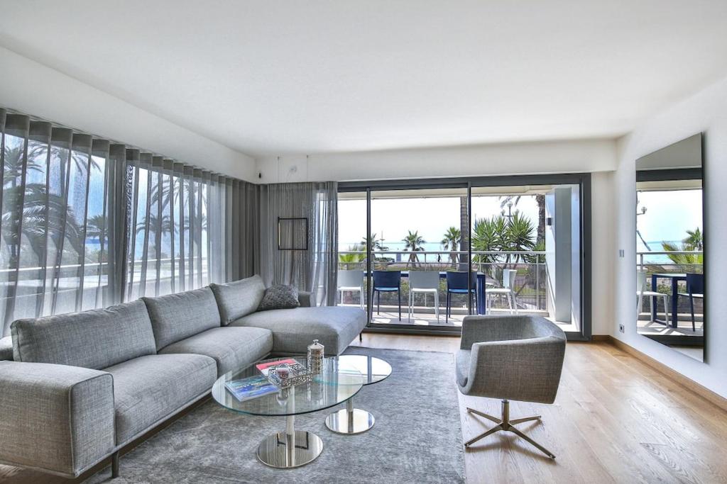 Sublime Appartement Promenade des Anglais (2) في نيس: غرفة معيشة مع أريكة وطاولة زجاجية