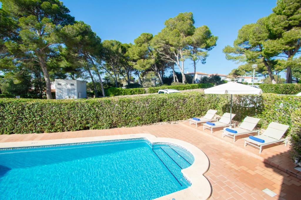 basen z 2 leżakami i parasolem w obiekcie Villa Felita by Sonne Villas w Cala Galdana