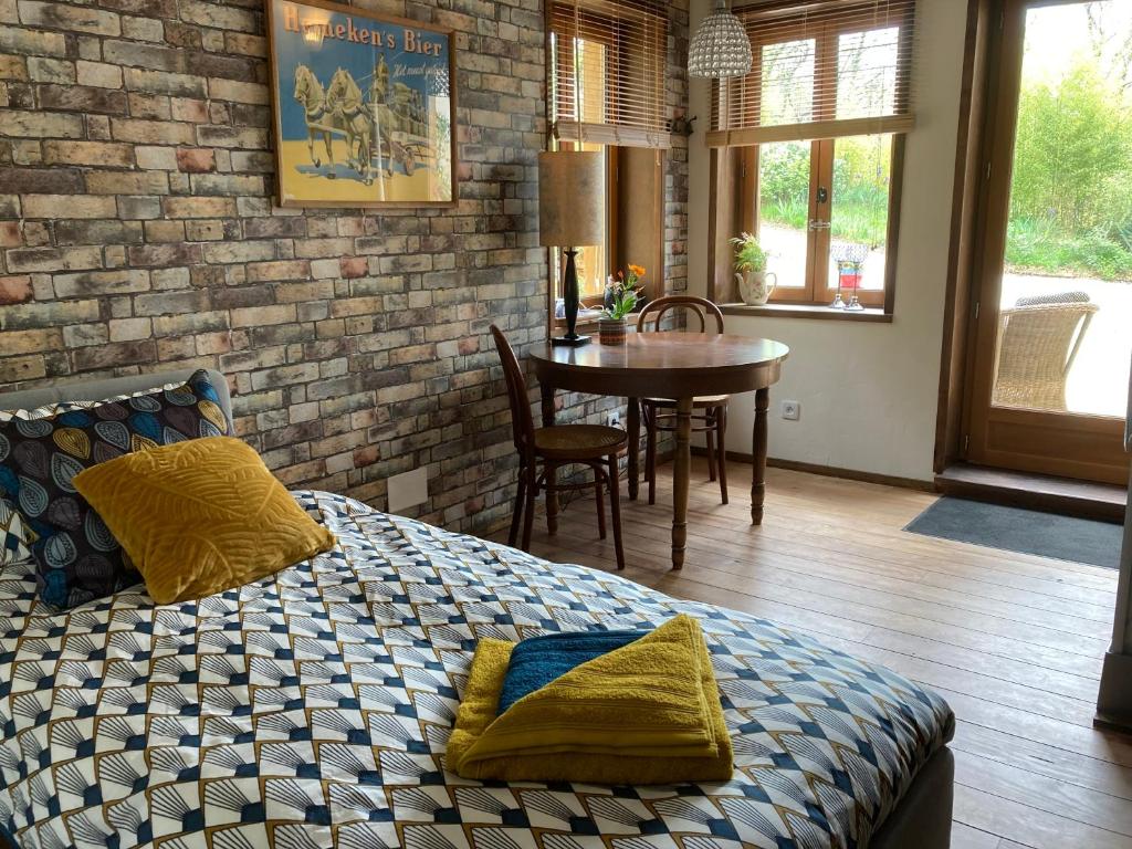 a bedroom with a bed and a dining room with a table at le bout du Bout in Les Arques