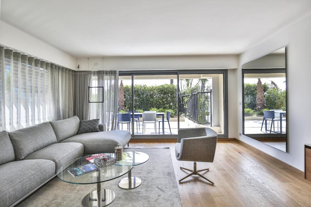 un salon avec un canapé et une table en verre dans l'établissement Sublime Appartement Promenade des Anglais RDJ, à Nice