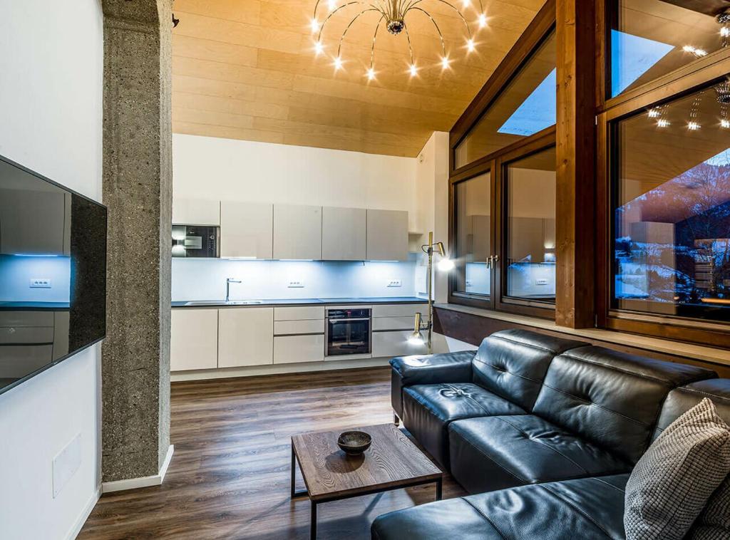 a living room with a leather couch and a table at Apartments Rumanon in Ortisei