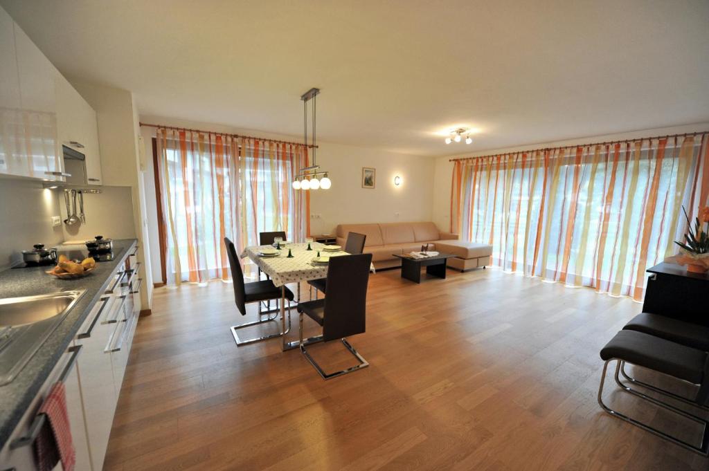 une cuisine et un salon avec une table et des chaises dans l'établissement Apartments Villa Jim, à Ortisei
