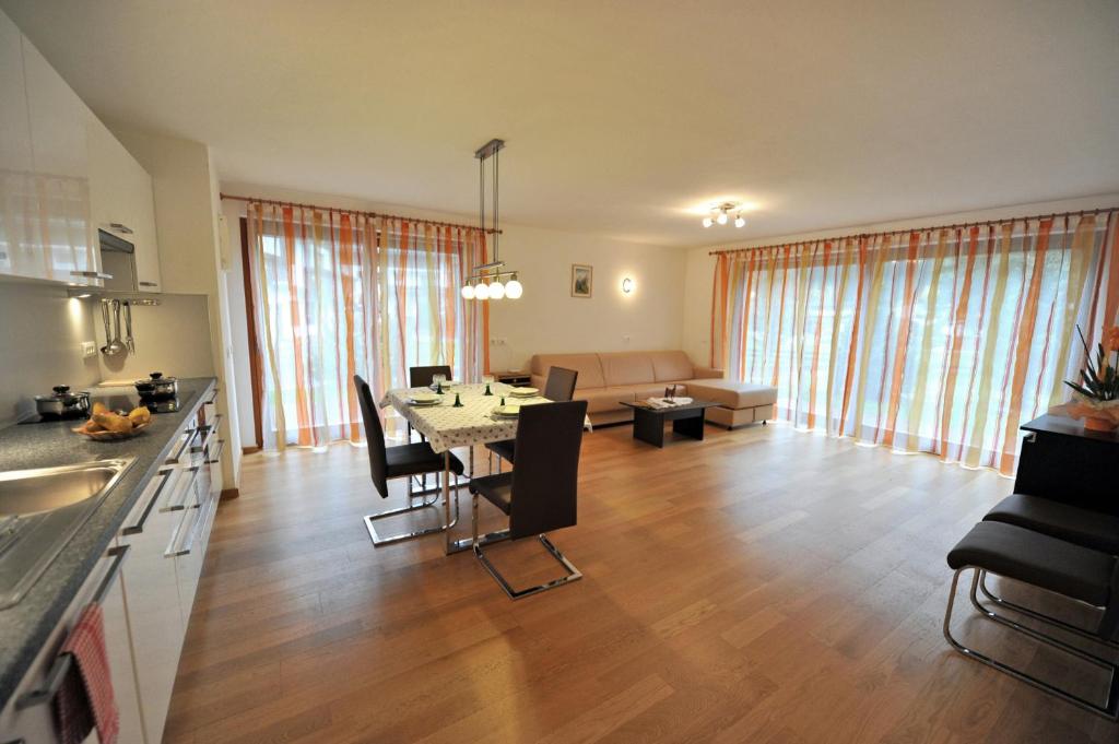 cocina y sala de estar con mesa y sillas en Apartments Villa Jim, en Ortisei