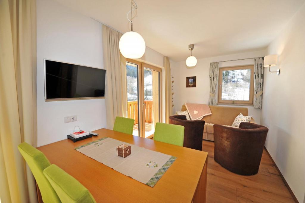 a living room with a dining room table and a living room at Apartments Cesa Leni in Ortisei