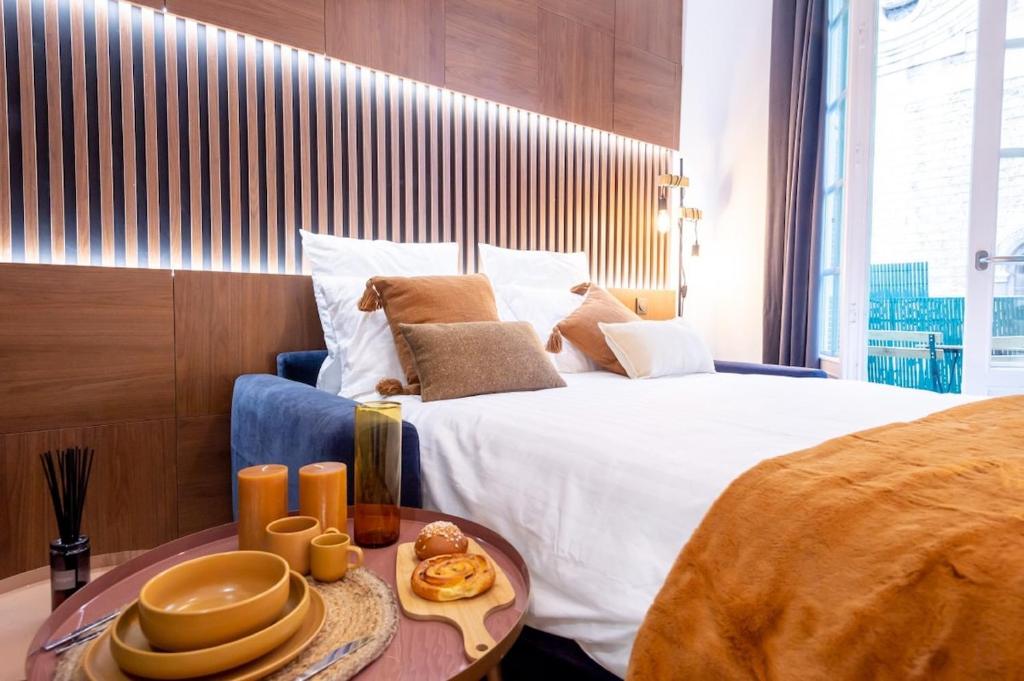 - une chambre avec un grand lit et une table avec de la vaisselle dans l'établissement Superbe studio balcon Plage/ Prom. des Anglais 103, à Nice