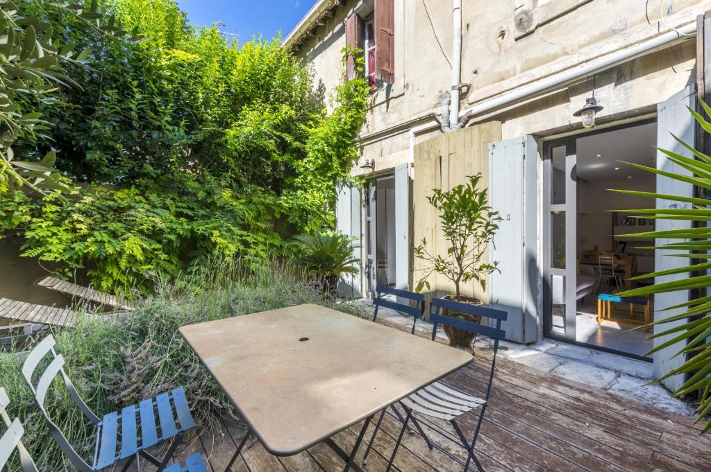 patio ze stołem i krzesłami przed budynkiem w obiekcie Un Jardin dans la ville - Premiere conciergerie w Montpellier