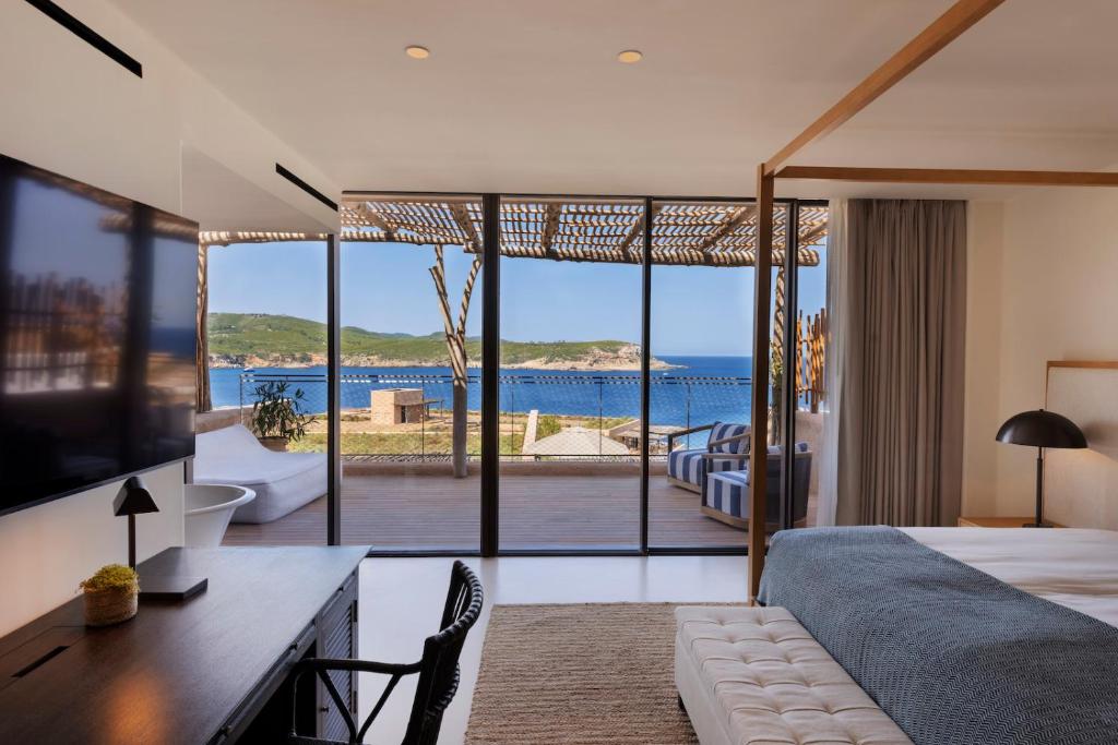 a bedroom with a bed and a view of the ocean at Six Senses Ibiza in Portinatx