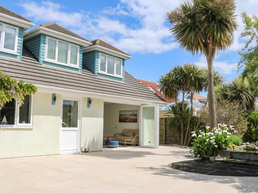 a house with palm trees in the yard at Wheatlands in South Hayling