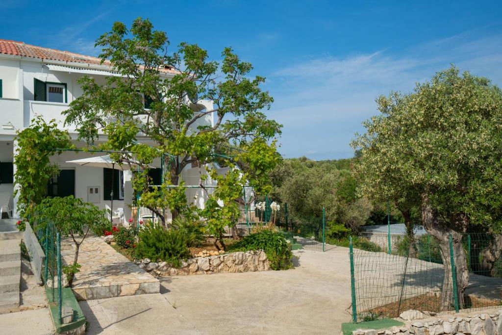 une maison avec une clôture et des arbres devant elle dans l'établissement Kuća za odmor Denona, à Borovići