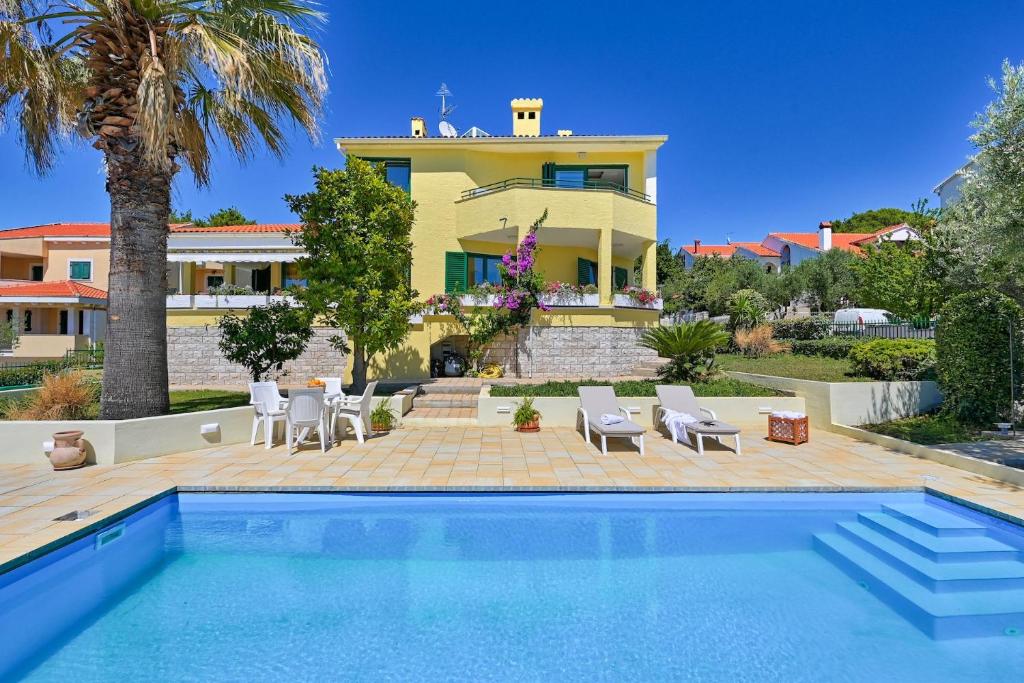 eine Villa mit einem Pool vor einem Haus in der Unterkunft Villa Oscar, Zadar in Zadar