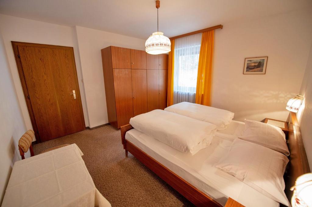 Un dormitorio con una cama y una mesa y una ventana. en Alara, en Ortisei