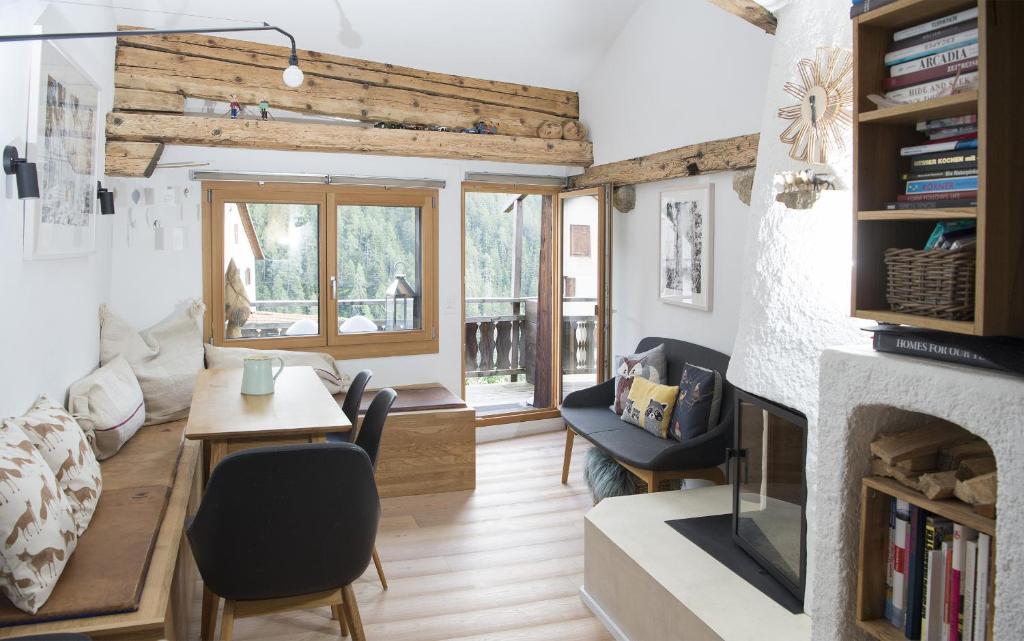 - un salon avec une cheminée, une table et des chaises dans l'établissement Rain Apartment with private spa area-Zorten-Lenzerheide, à Obervaz